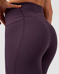 Woman wearing Elixir Ultra High-Rise 7/8 Legging Pockets - Midnight Plum | Model:Emelia | Size:S | Thumbnail Index: 8