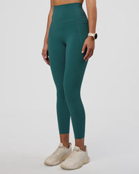 Woman wearing Elixir Ultra High-Rise 7/8 Legging Pockets - Transformative Teal | Model:Myrte | Size:S | Thumbnail Index: 1