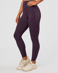 Woman wearing Elixir Ultra High-Rise Full Length Legging Pockets - Midnight Plum | Model:Emelia | Size:S | Thumbnail Index: 0