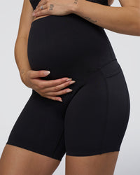 Woman wearing Elixir Ultra High-Rise Maternity 6" Short Pockets - Black | Model:Kitahna | Size:S | Thumbnail Index: 5