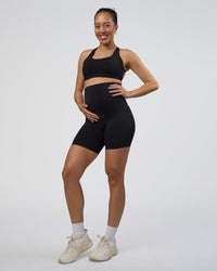 Woman wearing Elixir Ultra High-Rise Maternity 6" Short Pockets - Black | Model:Kitahna | Size:S | Thumbnail Index: 0