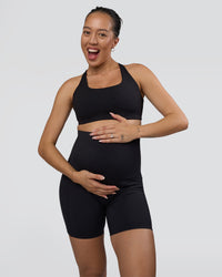 Woman wearing Elixir Ultra High-Rise Maternity 6" Short Pockets - Black | Model:Kitahna | Size:S | Thumbnail Index: 4