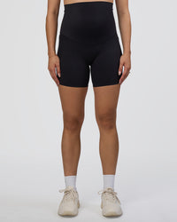 Woman wearing Elixir Ultra High-Rise Maternity 6" Short Pockets - Black | Model:Kitahna | Size:S | Thumbnail Index: 7