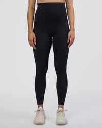 Woman wearing Elixir Ultra High-Rise Maternity Full Length Legging Pockets - Black | Model:Kitahna | Size:S | Thumbnail Index: 7