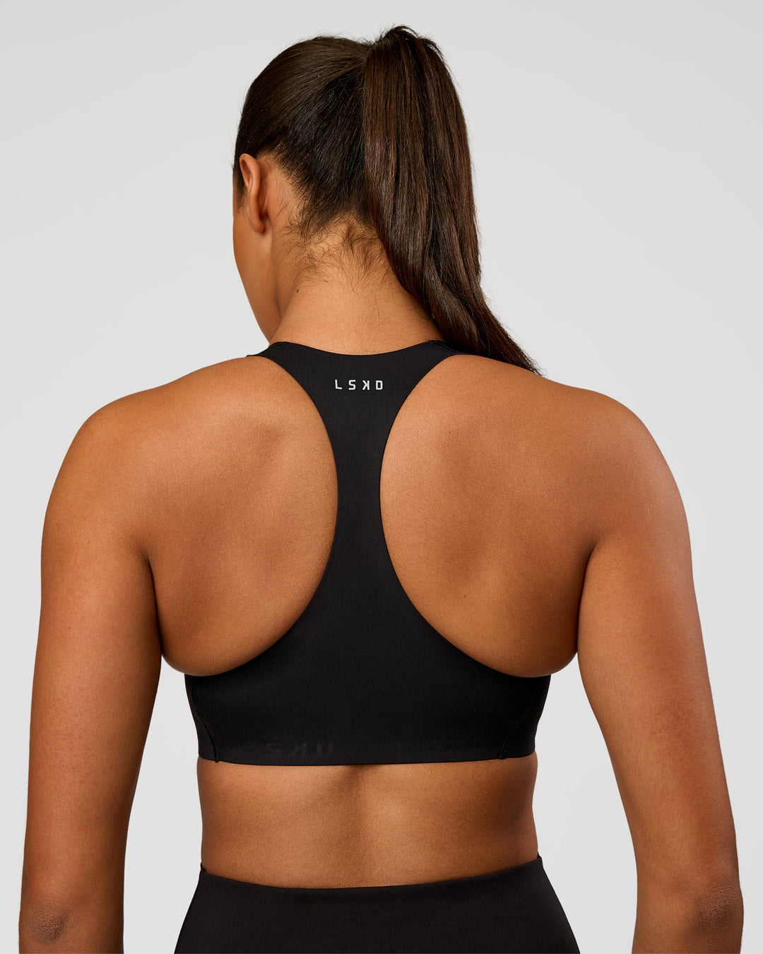 Woman wearing Flow Bonded Scoop Neck Sports Bra - Black | Model:Rosie | Size:S - view 2