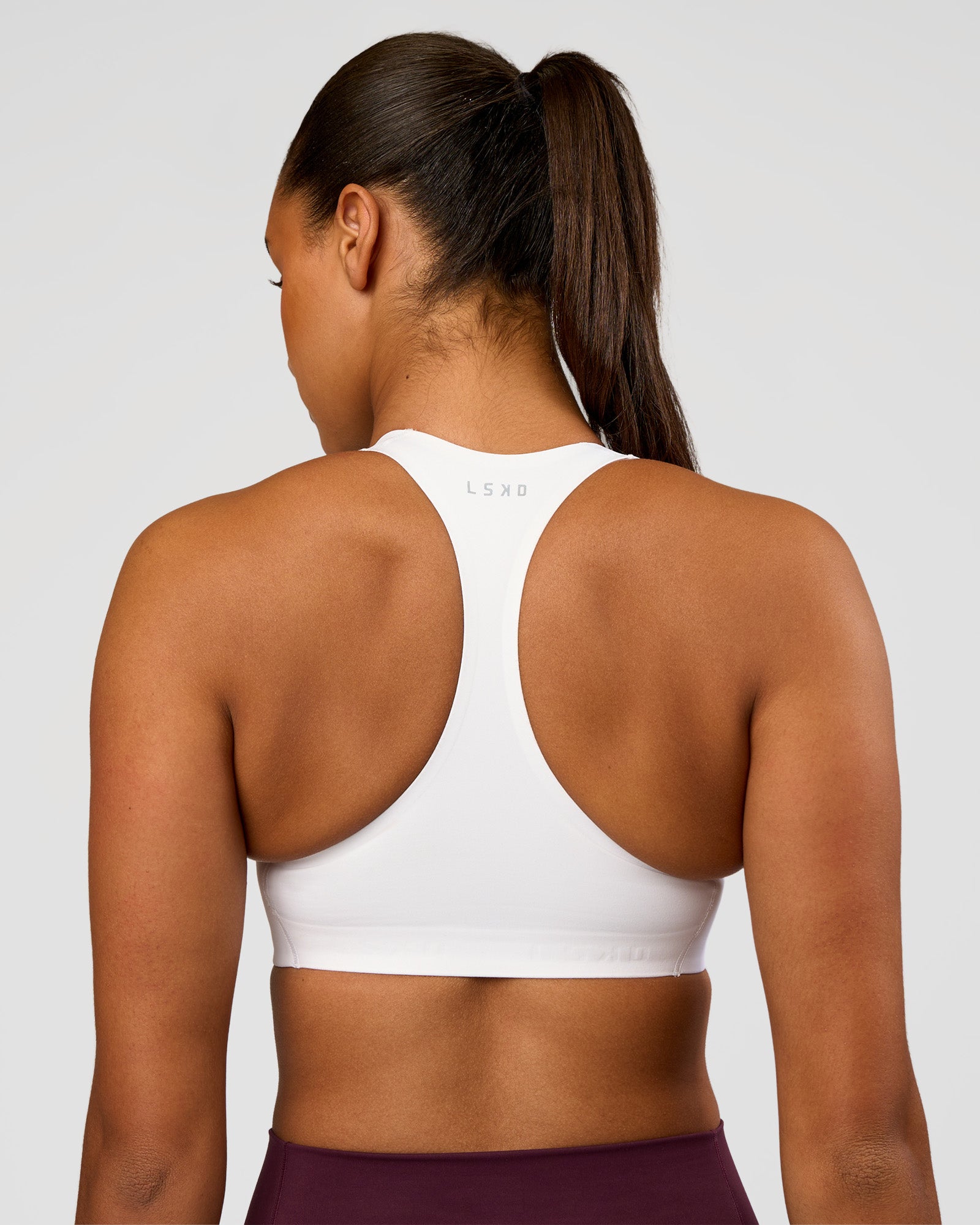 Woman wearing Flow Bonded Scoop Neck Sports Bra - White | Model:Rosie | Size:S