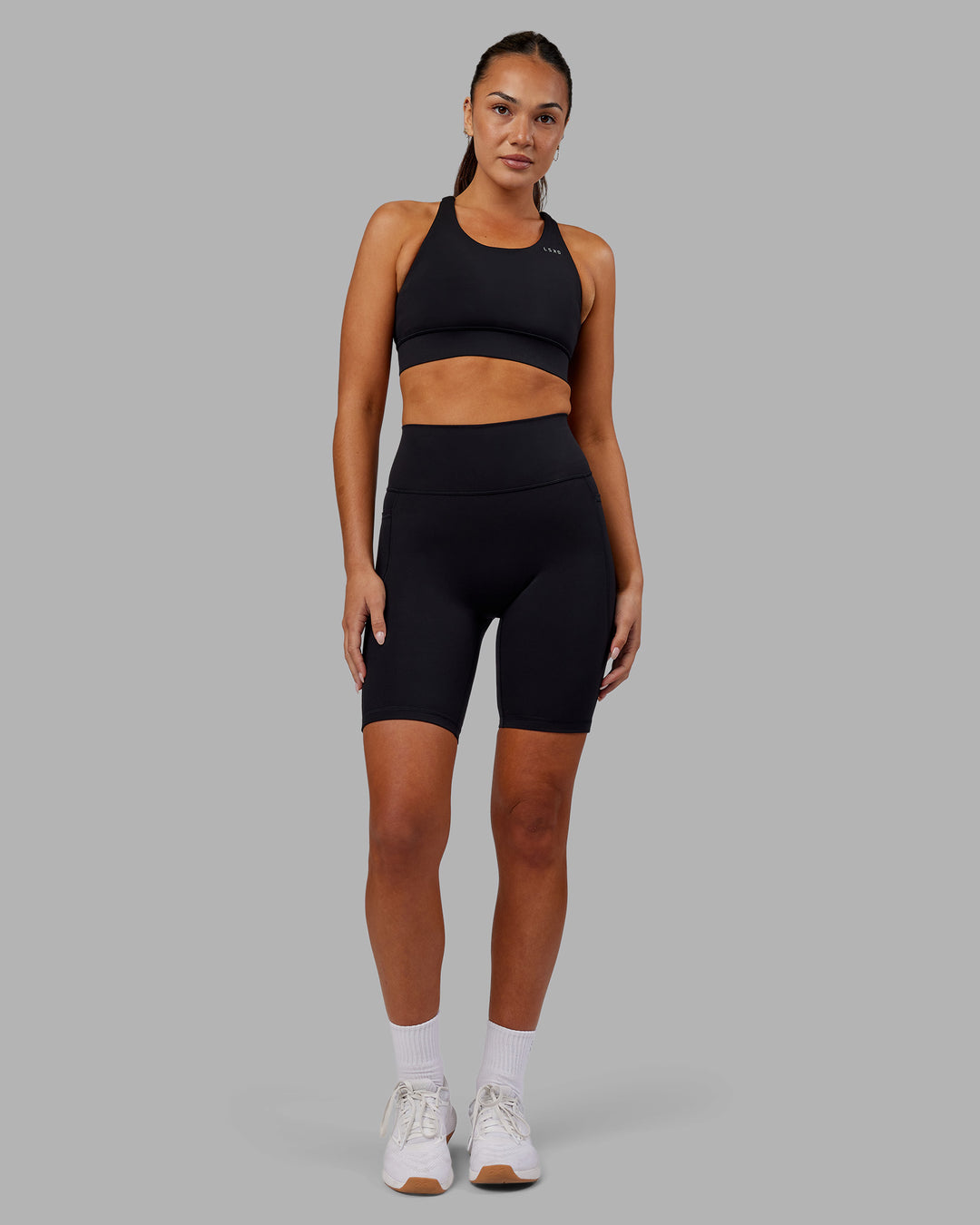 Woman wearing Fusion Ultra High-Rise 9" Short Pockets - Black | Model:Kirstyn | Size:S - view 1