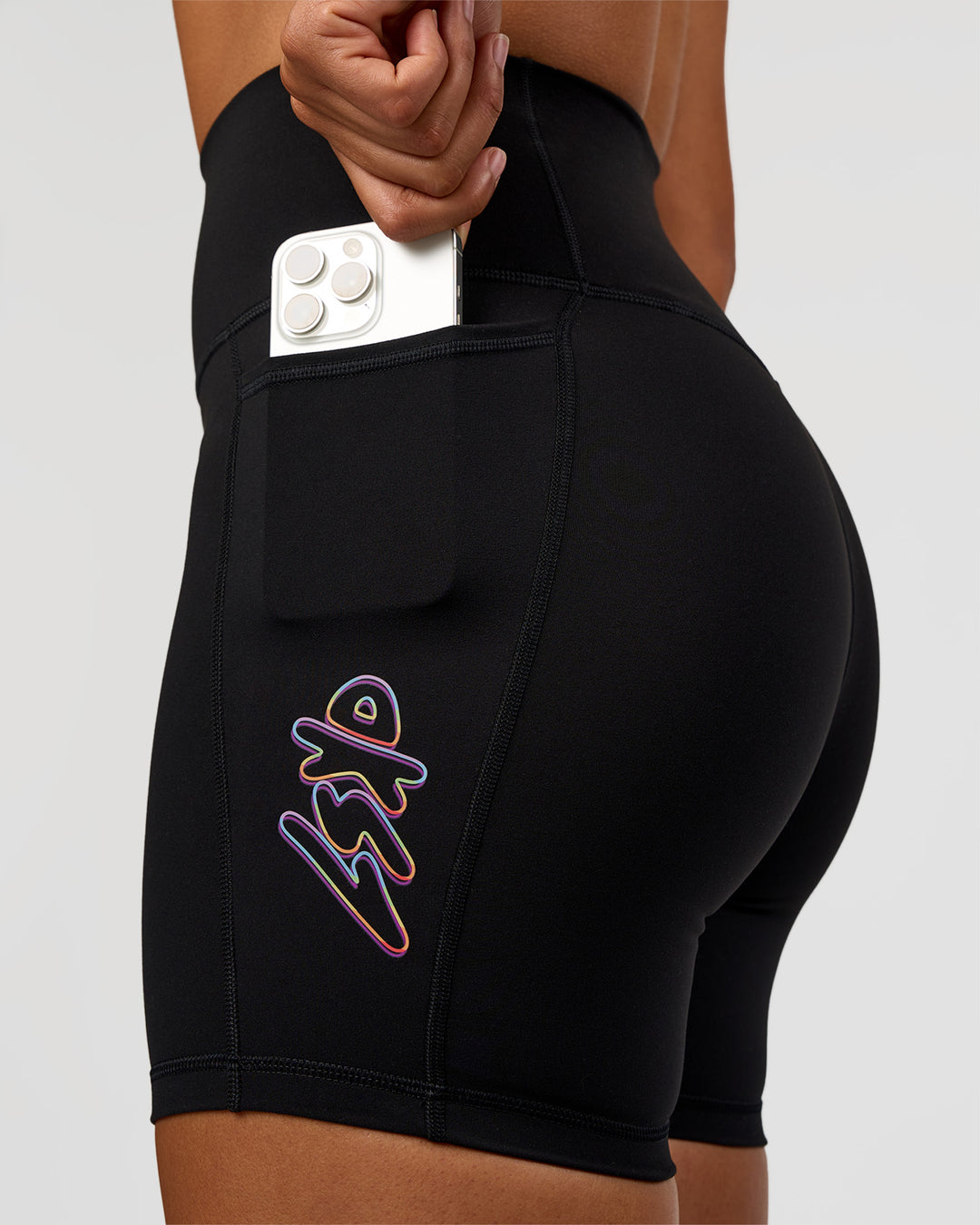 Woman wearing Fusion Graphic Ultra High-Rise 6" Short Pockets - Black-Radiate | Model:Rosie | Size:S - view 1