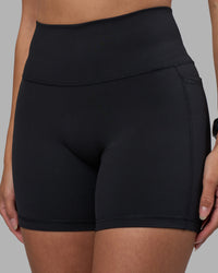 Woman wearing Fusion High-Rise 6" Short Pockets - Black | Model:Rhiley | Size:S | Thumbnail Index: 0