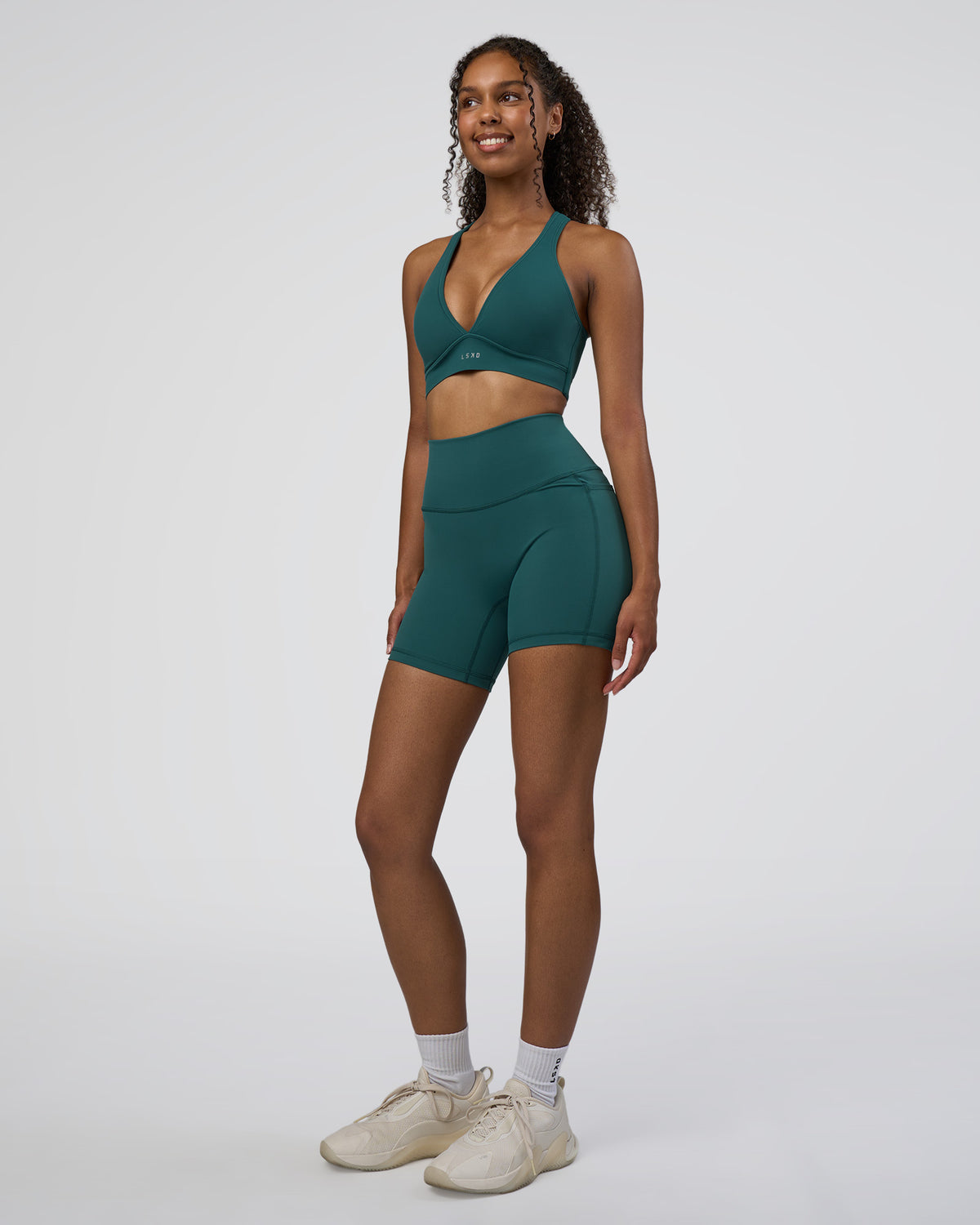 Woman wearing Fusion High-Rise 6" Short Pockets - Transformative Teal | Model:Jordan | Size:S