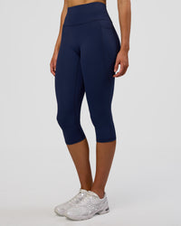 Woman wearing Fusion Ultra High-Rise 3/4 Legging Pockets - Future Navy | Model:Evie | Size:S | Thumbnail Index: 0