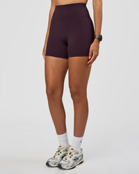 Woman wearing Fusion Ultra High-Rise 4" Short - Midnight Plum | Set:true | Angle:side | Model:Rhiley | Size:S | Thumbnail Index: 1