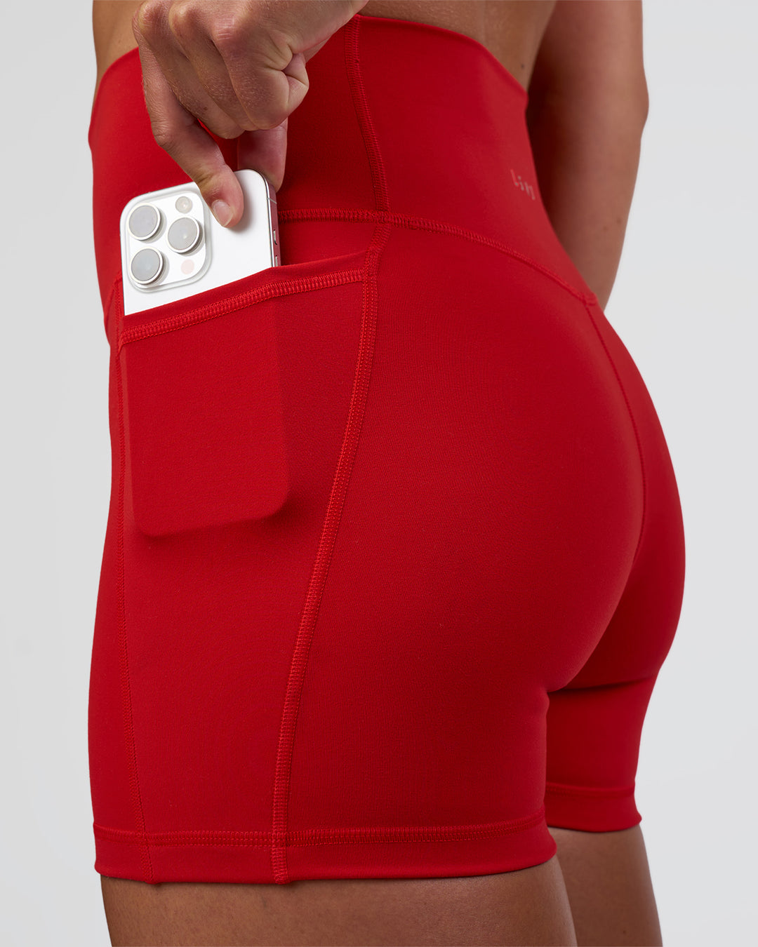 Woman wearing Fusion Ultra High-Rise 4" Short Pockets - Flame | Set:true | Angle:closeup | Model:Sav | Size:S - view 3
