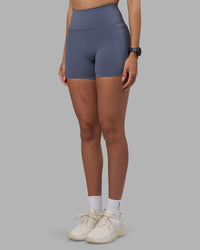 Woman wearing Fusion Ultra High-Rise 4" Short Pockets - Night Shadow | Set:true | Angle:side | Model:Rhiley | Size:S | Thumbnail Index: 2