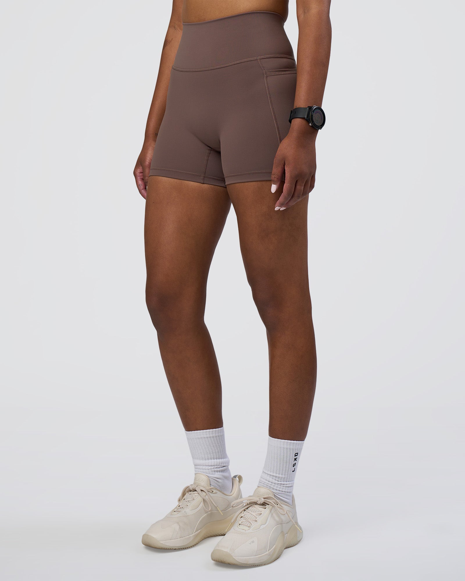 Woman wearing Fusion Ultra High-Rise 4" Short Pockets - Peppercorn | Set:true | Angle:side | Model:Rica | Size:S
