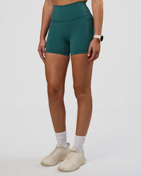 Woman wearing Fusion Ultra High-Rise 4" Short Pockets - Transformative Teal | Set:true | Angle:side | Model:Myrte | Size:S | Thumbnail Index: 0