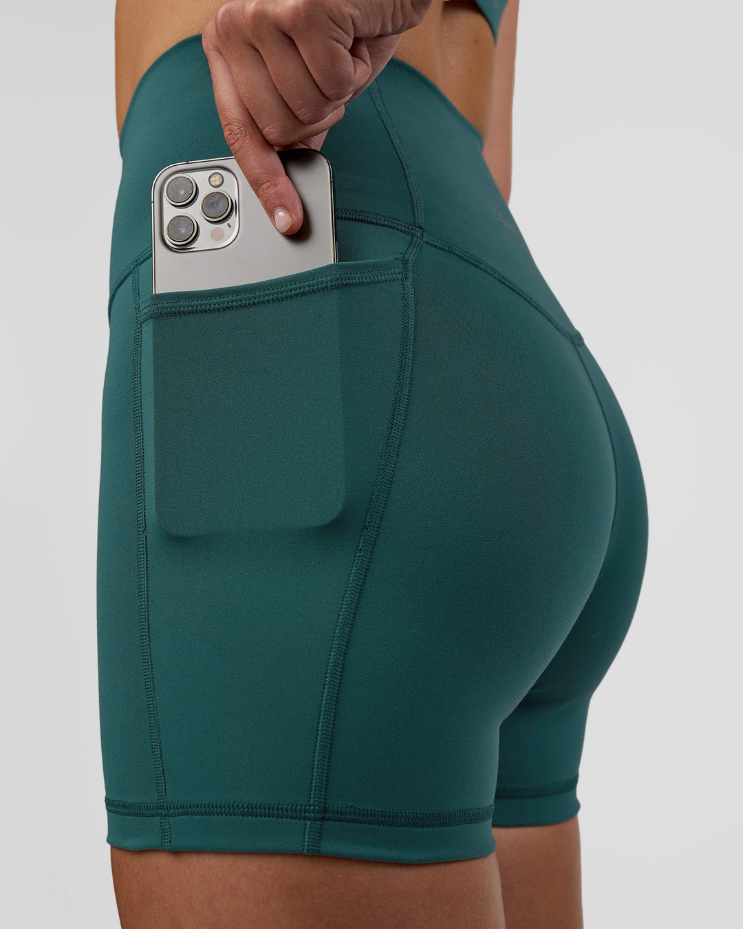 Woman wearing Fusion Ultra High-Rise 4" Short Pockets - Transformative Teal | Set:true | Angle:closeup | Model:Myrte | Size:S - view 3