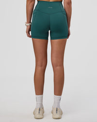 Woman wearing Fusion Ultra High-Rise 4" Short Pockets - Transformative Teal | Set:true | Angle:back | Model:Myrte | Size:S | Thumbnail Index: 3