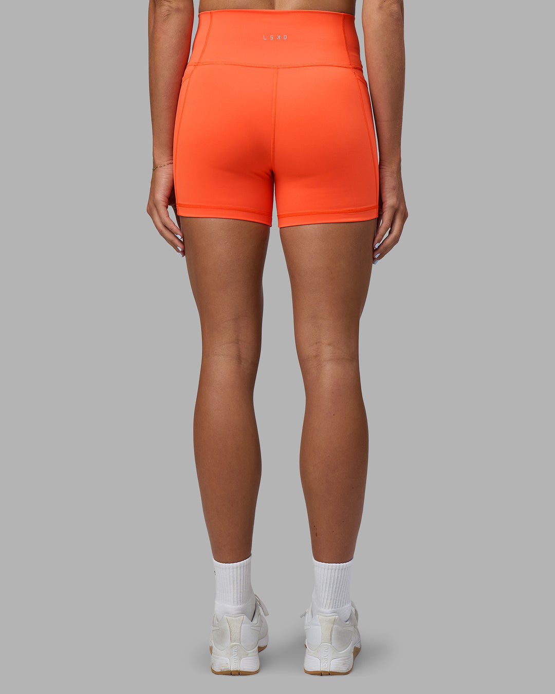 Woman wearing Fusion Ultra High-Rise 4" Short Pockets - Ultra Orange | Set:true | Angle:back | Model:Katie | Size:S - view 8