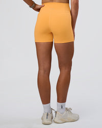 Woman wearing Fusion Ultra High-Rise 4" Short Pockets - Warm Apricot | Set:true | Angle:back | Model:Emelia | Size:S | Thumbnail Index: 2