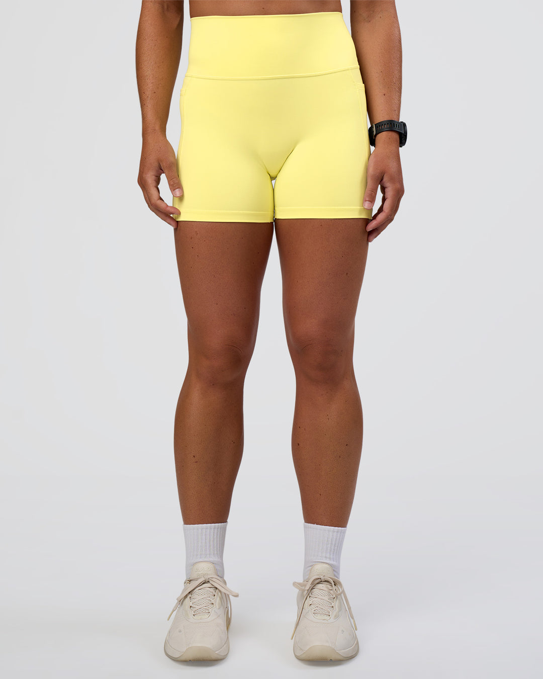 Woman wearing Fusion Ultra High-Rise 4" Short Pockets - Yellow Fizz | Set:true | Angle:front | Model:Sav | Size:S - view 7