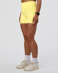 Woman wearing Fusion Ultra High-Rise 4" Short Pockets - Yellow Fizz | Set:true | Angle:side | Model:Sav | Size:S | Thumbnail Index: 2