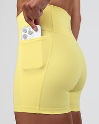 Woman wearing Fusion Ultra High-Rise 4" Short Pockets - Yellow Fizz | Set:true | Angle:closeup | Model:Sav | Size:S | Thumbnail Index: 0