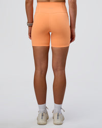Woman wearing Fusion Ultra High-Rise 6" Short Pockets - Cantaloupe | Set:true | Angle:back | Model:Emelia | Size:S | Thumbnail Index: 3