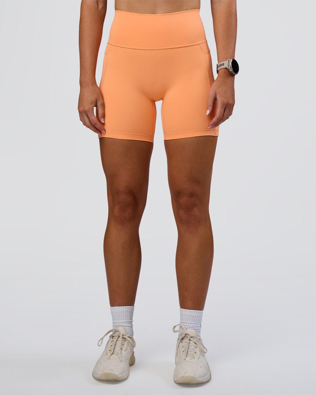 Woman wearing Fusion Ultra High-Rise 6" Short Pockets - Cantaloupe | Set:true | Angle:front | Model:Emelia | Size:S - view 3