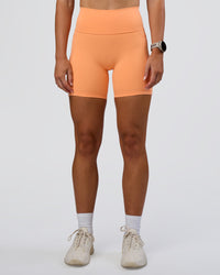 Woman wearing Fusion Ultra High-Rise 6" Short Pockets - Cantaloupe | Set:true | Angle:front | Model:Emelia | Size:S | Thumbnail Index: 2