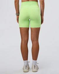 Woman wearing Fusion Ultra High-Rise 6" Short Pockets - Solar Lime | Set:true | Angle:back | Model:Emelia | Size:S | Thumbnail Index: 3