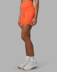 Woman wearing Fusion Ultra High-Rise 6" Short Pockets - Ultra Orange | Set:true | Angle:side | Model:Katie | Size:S | Thumbnail Index: 4