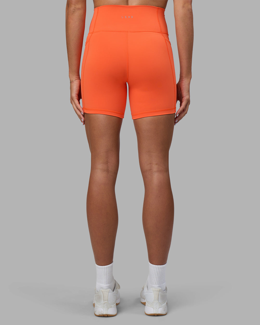 Woman wearing Fusion Ultra High-Rise 6" Short Pockets - Ultra Orange | Set:true | Angle:back | Model:Katie | Size:S - view 4