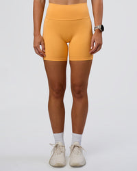 Woman wearing Fusion Ultra High-Rise 6" Short Pockets - Warm Apricot | Set:true | Angle:front | Model:Emelia | Size:S | Thumbnail Index: 0