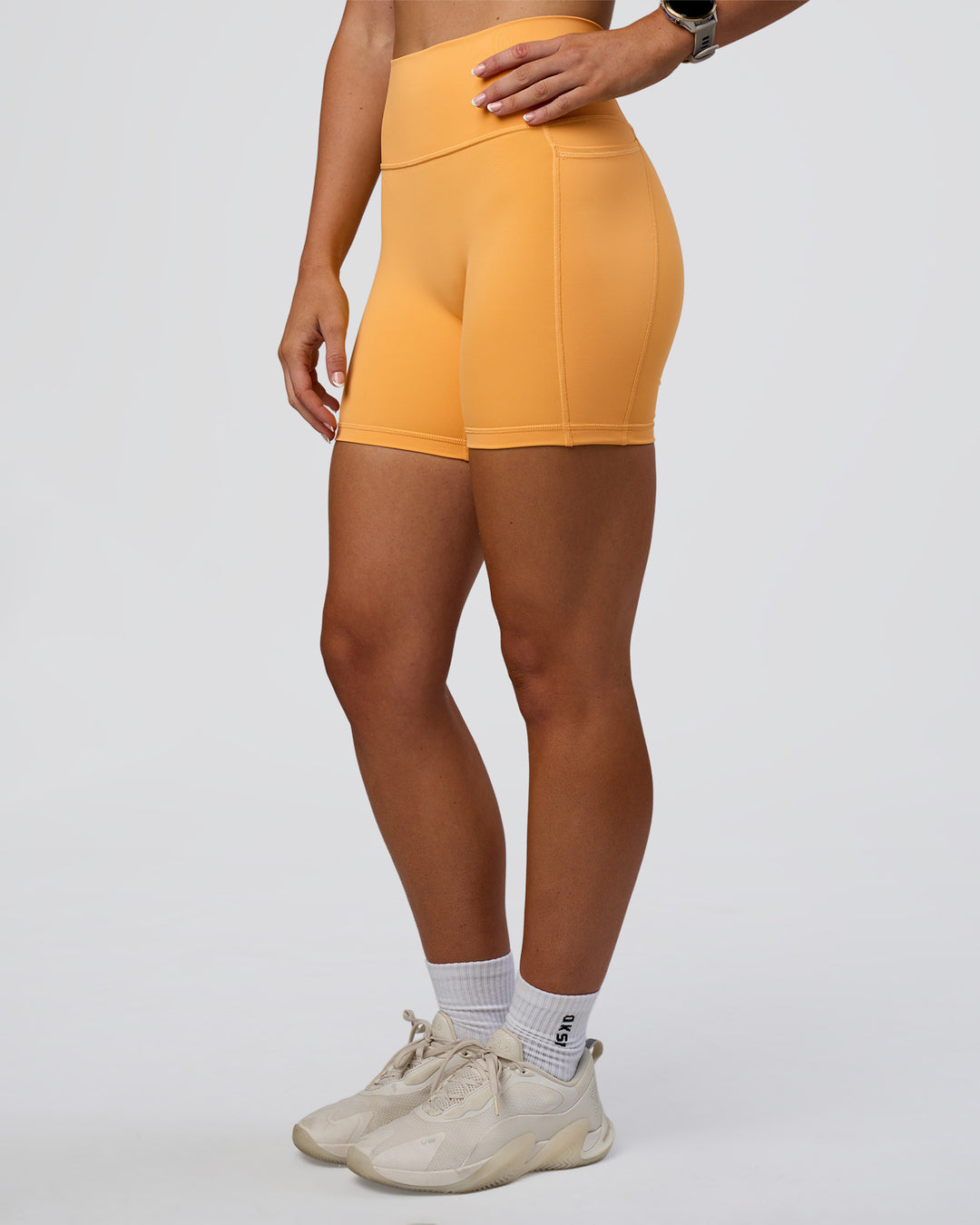 Woman wearing Fusion Ultra High-Rise 6" Short Pockets - Warm Apricot | Set:true | Angle:side | Model:Emelia | Size:S - view 7