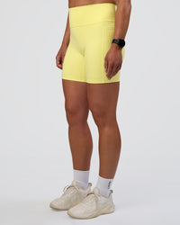Woman wearing Fusion Ultra High-Rise 6" Short Pockets - Yellow Fizz | Set:true | Angle:side | Model:Sav | Size:S | Thumbnail Index: 6