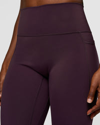 Woman wearing Fusion Ultra High-Rise 7/8 Legging Pockets - Midnight Plum | Model:Ellie | Size:S | Thumbnail Index: 2