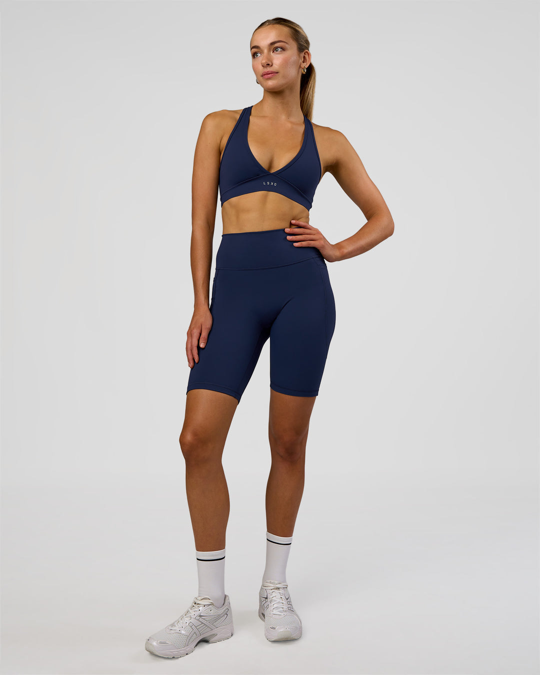 Woman wearing Fusion Ultra High-Rise 9" Short Pockets - Future Navy | Model:Evie | Size:S - view 1