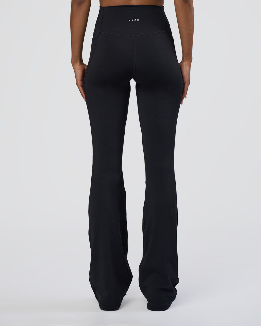 Woman wearing Fusion Ultra High-Rise Flared Tall Legging Pockets - Black | Model:Tomi | Size:S - view 4