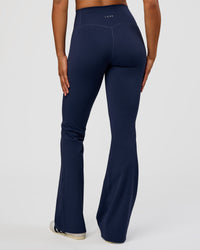 Woman wearing Fusion V-Contour High-Rise Flared Tall Legging Pockets - Future Navy | Model:Rosie | Size:S | Thumbnail Index: 0
