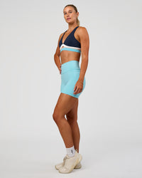 Woman wearing Fusion V-Contour Ultra High-Rise 4” Short Pockets - Baltic Sea | Model:Emelia | Size:S | Thumbnail Index: 2