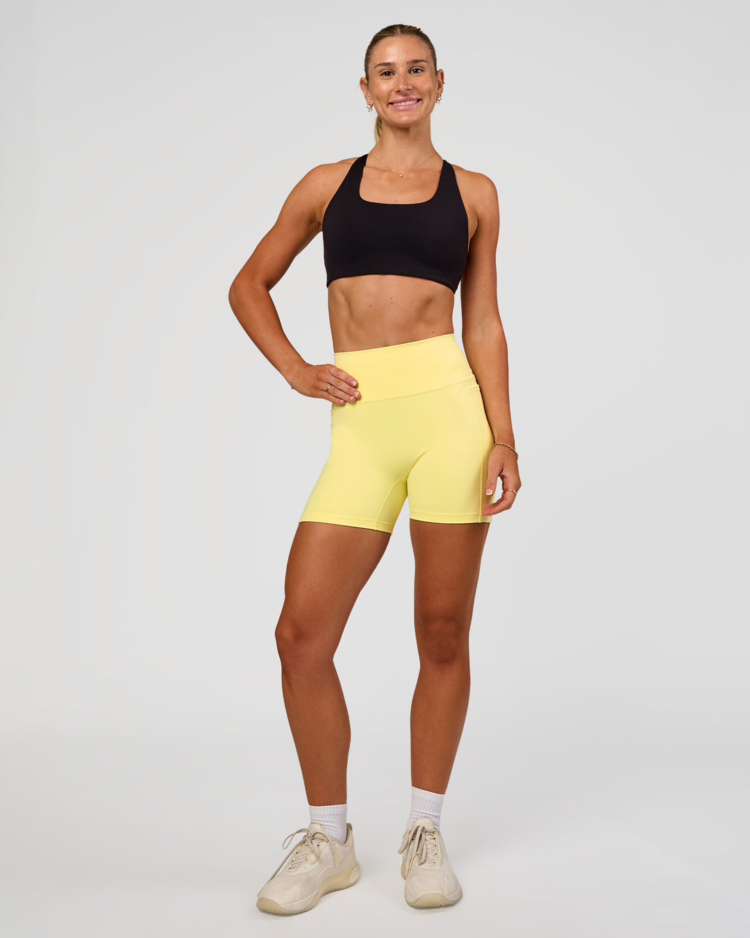 Woman wearing Fusion V-Contour Ultra High-Rise 4” Short Pockets - Yellow Fizz | Model:Emelia | Size:S - view 3