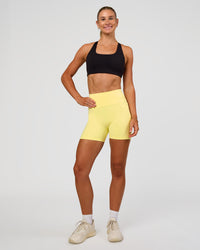 Woman wearing Fusion V-Contour Ultra High-Rise 4” Short Pockets - Yellow Fizz | Model:Emelia | Size:S | Thumbnail Index: 2
