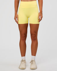 Woman wearing Fusion V-Contour Ultra High-Rise 4” Short Pockets - Yellow Fizz | Model:Emelia | Size:S | Thumbnail Index: 4