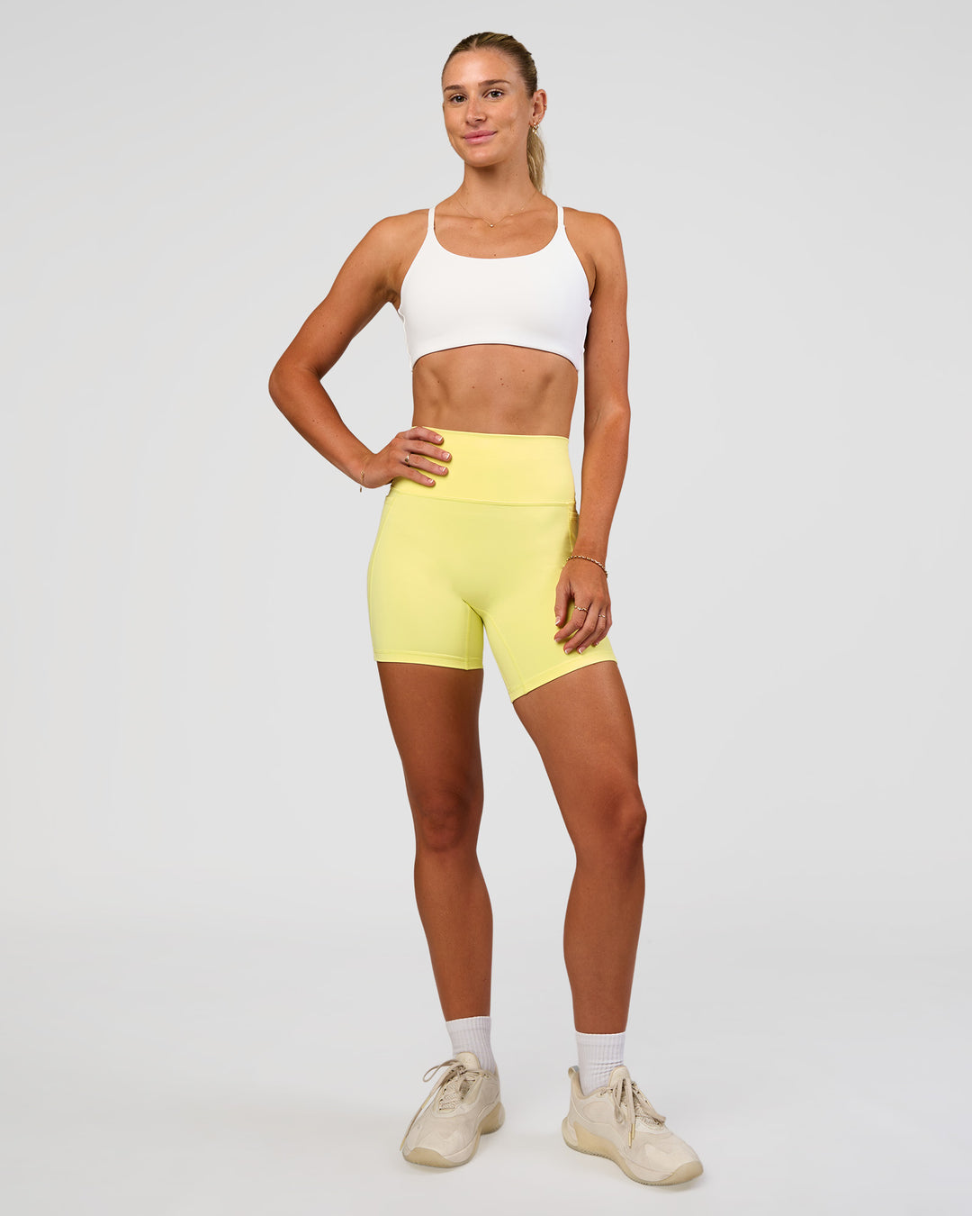 Woman wearing Fusion V-Contour Ultra High-Rise 6" Short Pockets - Yellow Fizz | Model:Emelia | Size:S - view 3