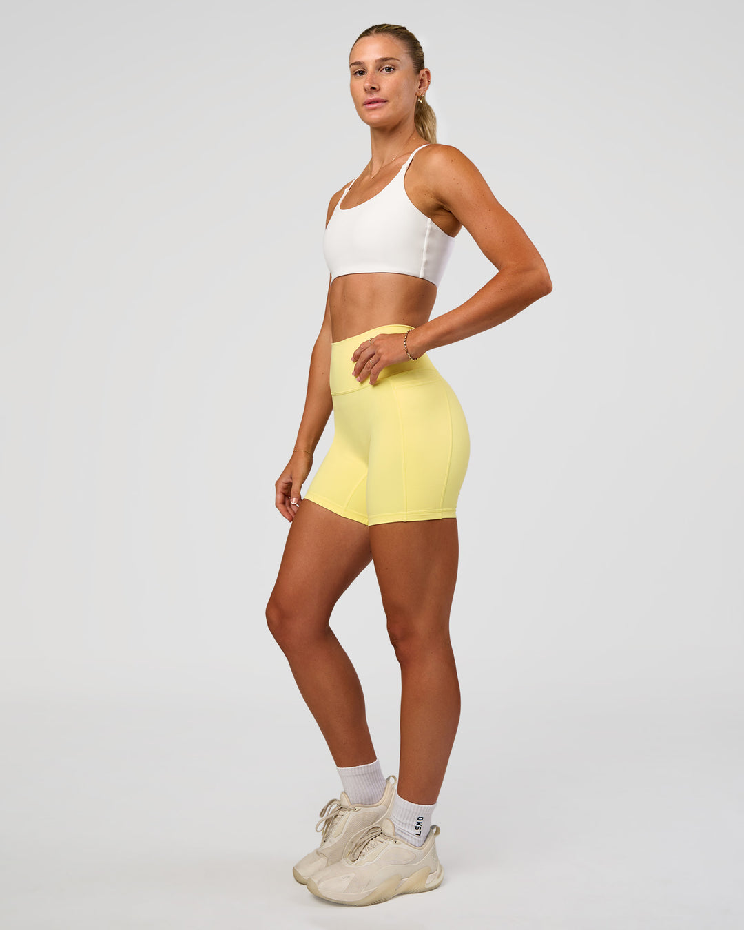 Woman wearing Fusion V-Contour Ultra High-Rise 6" Short Pockets - Yellow Fizz | Model:Emelia | Size:S - view 6