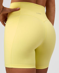 Woman wearing Fusion V-Contour Ultra High-Rise 6" Short Pockets - Yellow Fizz | Model:Emelia | Size:S | Thumbnail Index: 0