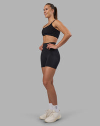 Woman wearing Fusion V-Contour Ultra High-Rise 4” Short Pockets - Black | Model:Charlize | Size:S | Thumbnail Index: 2