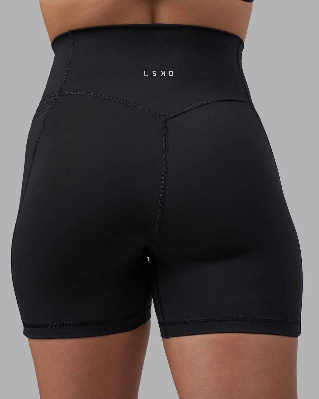 Woman wearing Fusion V-Contour Ultra High-Rise 4” Short Pockets - Black | Model:Charlize | Size:S - view 10