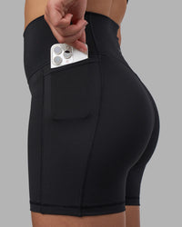 Woman wearing Fusion V-Contour Ultra High-Rise 4” Short Pockets - Black | Model:Charlize | Size:S | Thumbnail Index: 5